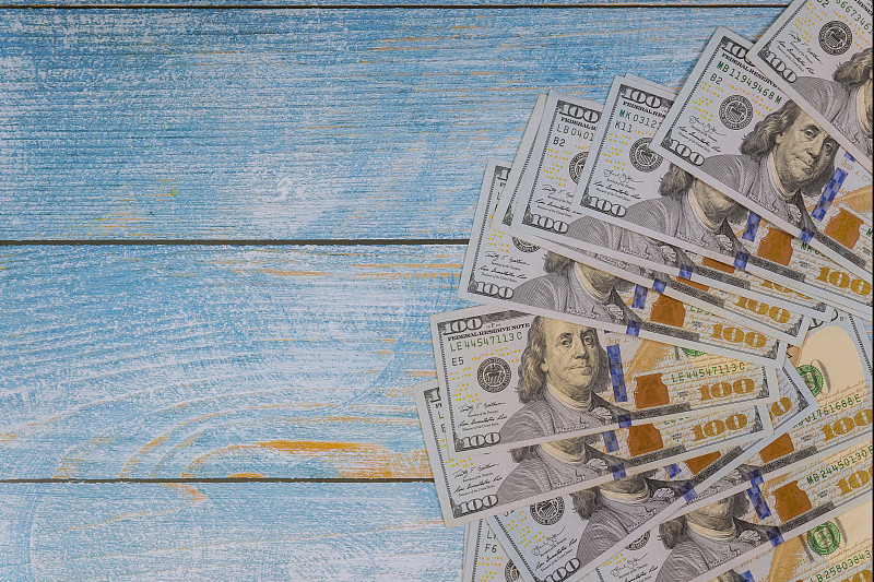 蓝色木质背景的百元钞票图片下载