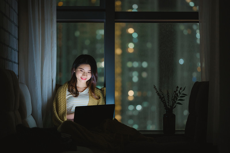 亚洲年轻女孩夜晚在家使用笔记本电脑图片下载
