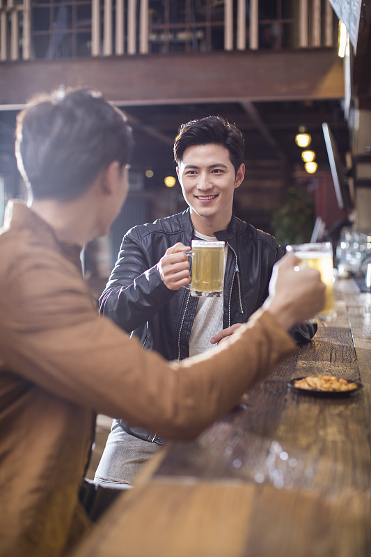 快乐的年轻男士在酒吧喝酒图片下载