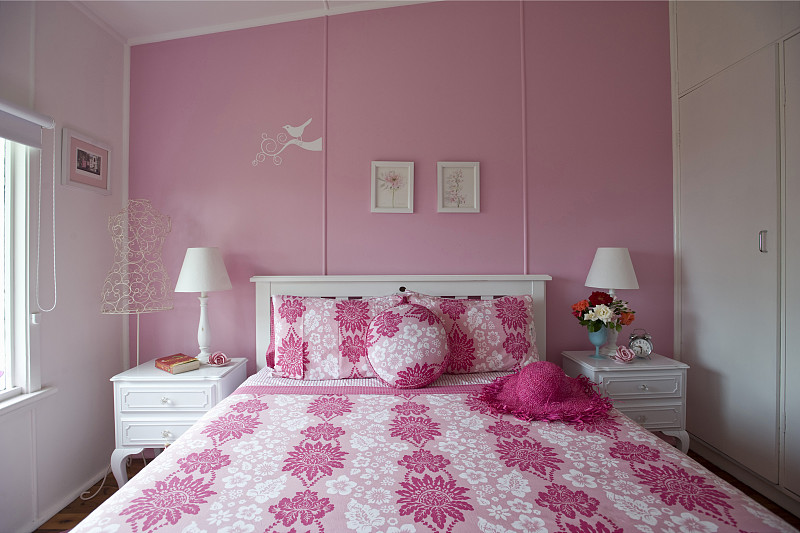 白色木床和白色床头柜在女性化，粉红色的卧室图片素材