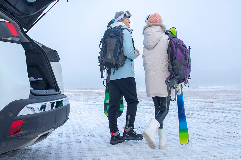青年伴侣拿着滑雪板的背影图片素材