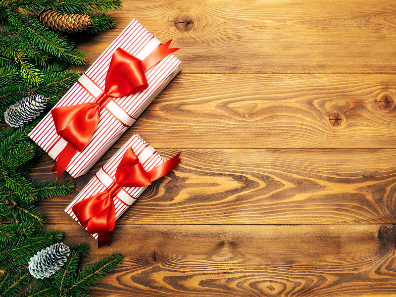 平铺着冷杉树枝和包装好的圣诞礼品盒图片素材