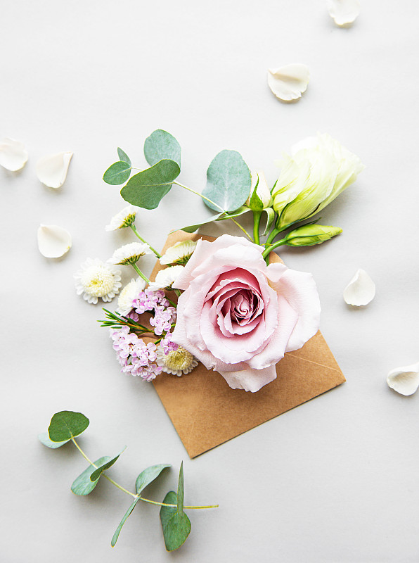 玫瑰花头和花瓣在信封上图片素材