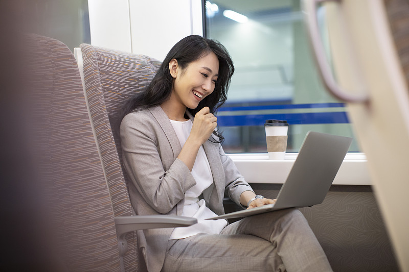 年轻商务女士在高铁上使用笔记本电脑图片下载