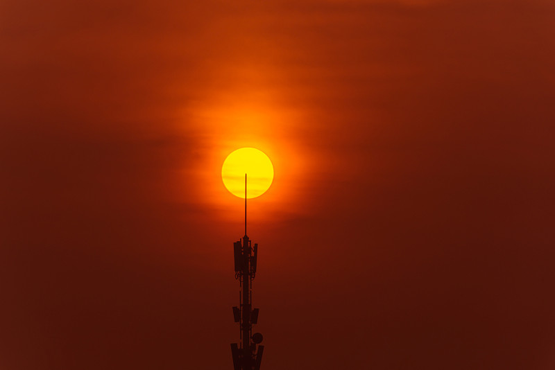 刚出生的红太阳划过电信信号塔图片素材