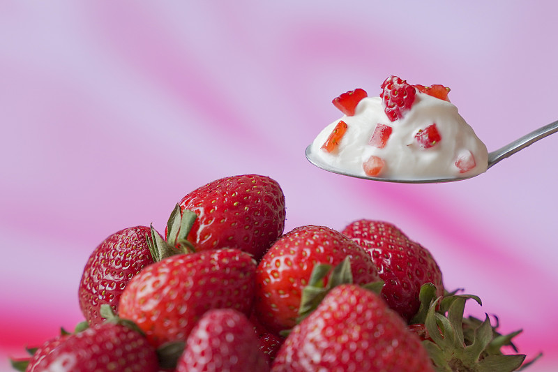 草莓酸奶在勺子里，以新鲜为背景图片素材