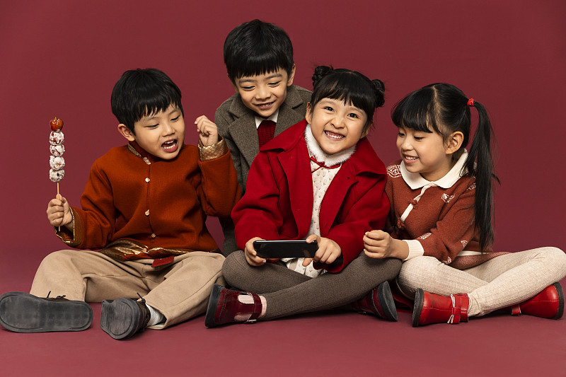 儿童庆祝春节系列：欢乐的小男孩和小女孩们用手机抢过年红包嬉戏玩耍图片下载