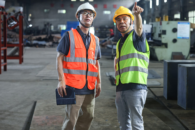 两位男性工程师在工厂车间检查工作图片下载