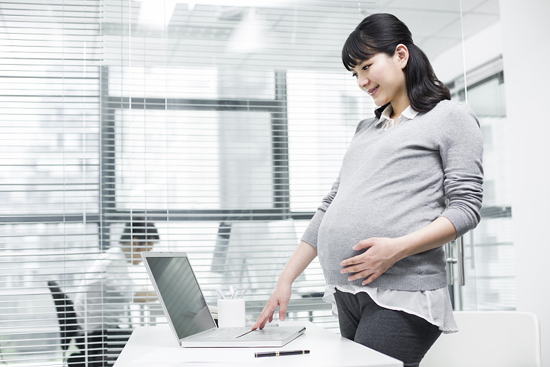 怀孕的商务女士使用笔记本电脑图片下载