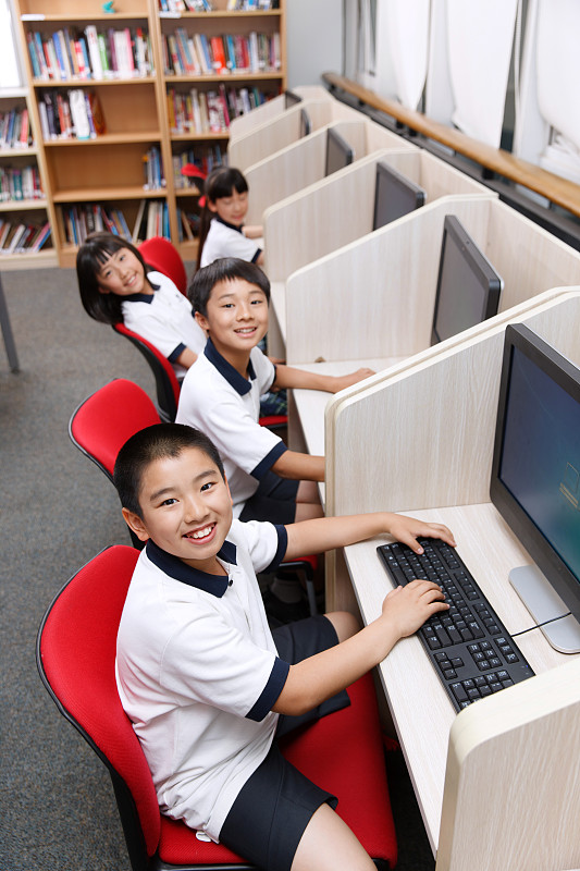 小学生在阅览室里使用电脑图片下载