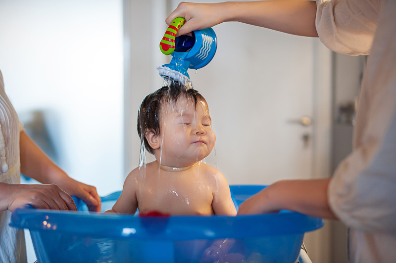 Baby boy being bathed by mother图片下载
