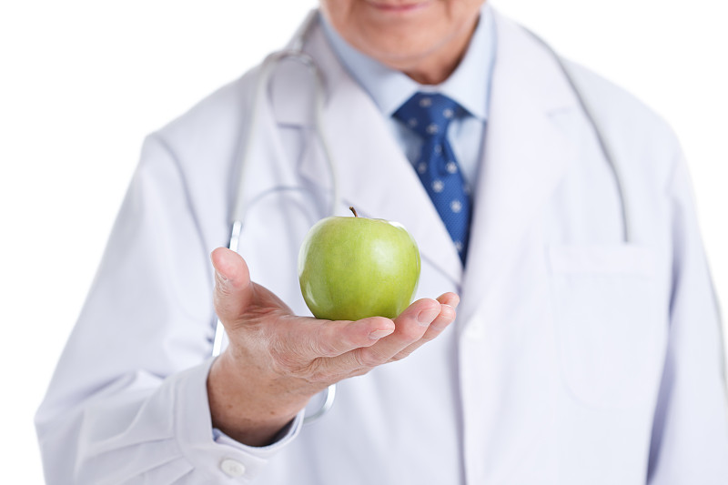 一个老年医生拿着青苹果图片素材