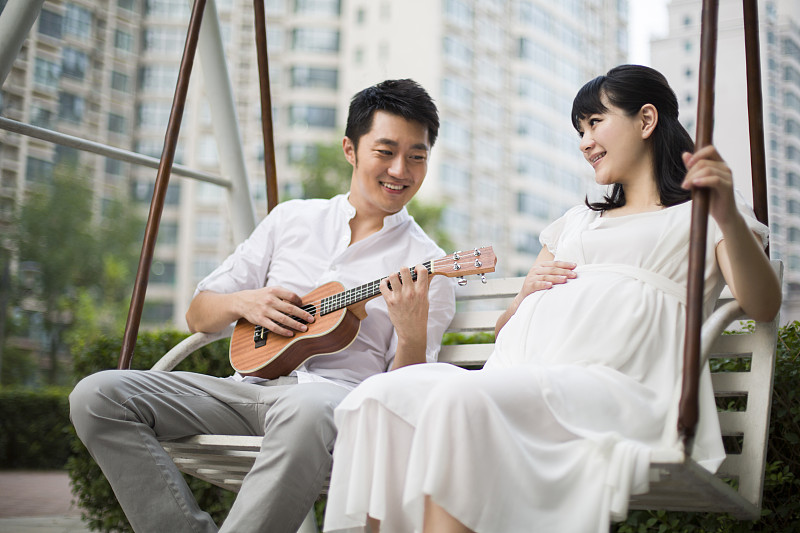 丈夫给怀孕的妻子弹吉他图片素材