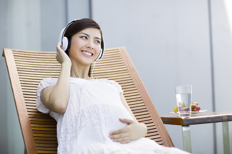 孕妇靠在躺椅上听音乐图片素材