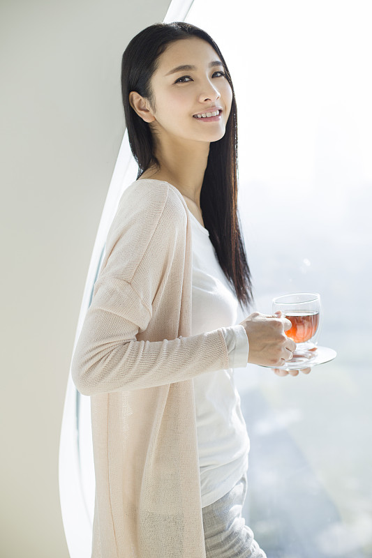 快乐的年轻女子喝红茶图片下载