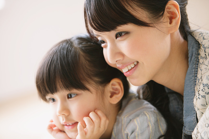 年轻的成年母亲和女儿微笑着看向别处图片下载
