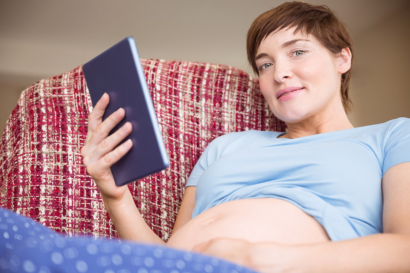 孕妇在客厅里使用平板电脑图片下载