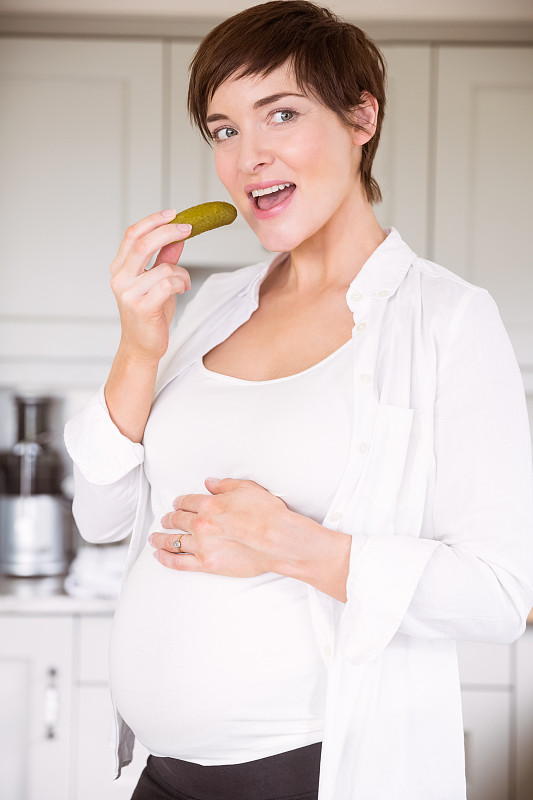 孕妇在家厨房吃泡菜罐图片下载