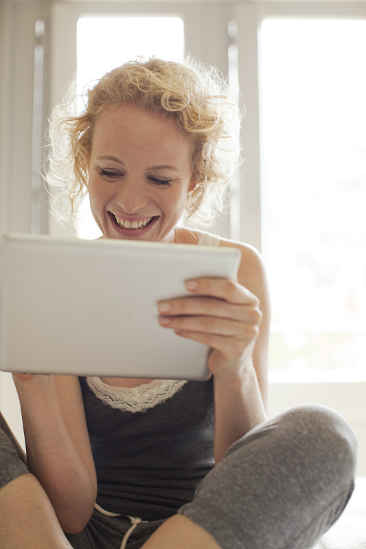 微笑的女人使用数码平板电脑图片下载