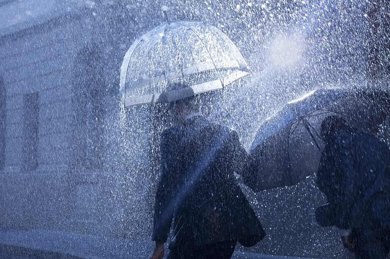 商人在雨中打着雨伞图片素材