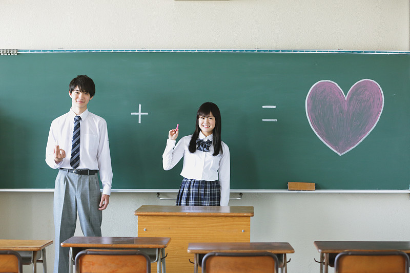 日本高中生站在教室的黑板前图片下载