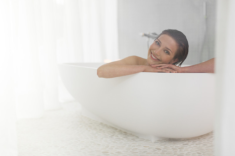 微笑的女人在现代浴室洗澡图片素材