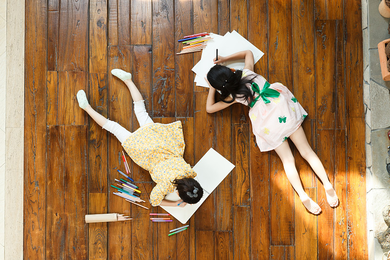 姐妹俩趴在地板上写字图片素材