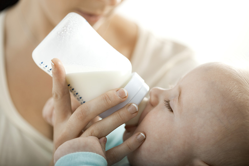 婴儿从奶瓶里喝牛奶图片下载