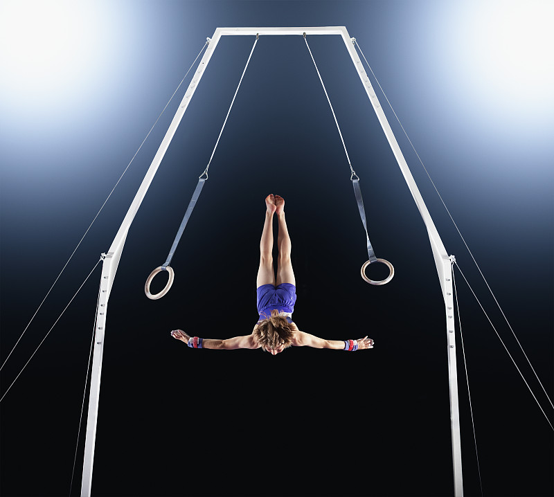 男子体操运动员从吊环上下来图片素材