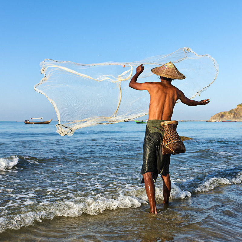 缅甸渔民在Ngapali海滩上撒网图片下载