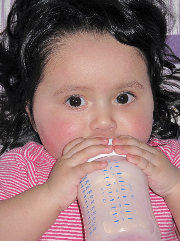 婴儿从瓶子里喝配方奶粉图片下载