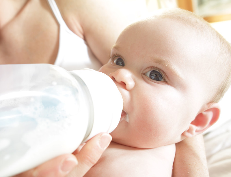 婴儿正在用奶瓶喂奶图片下载