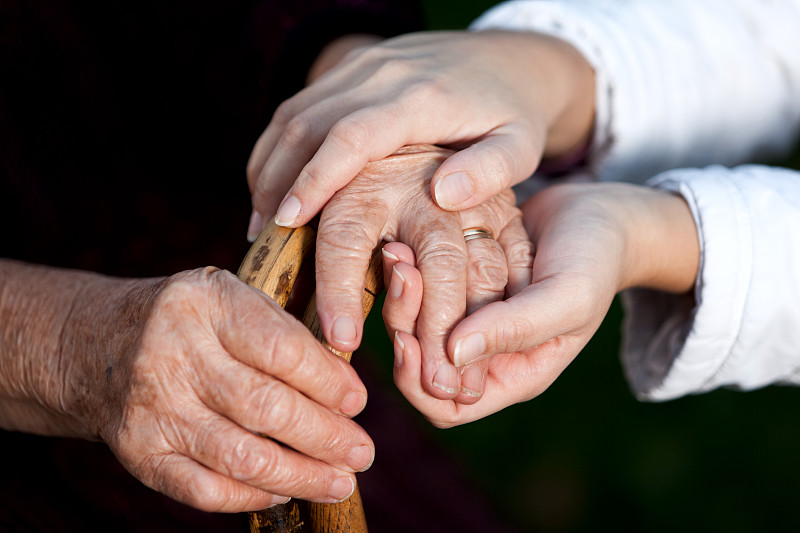 年轻人帮助老年妇女，手牵手图片下载