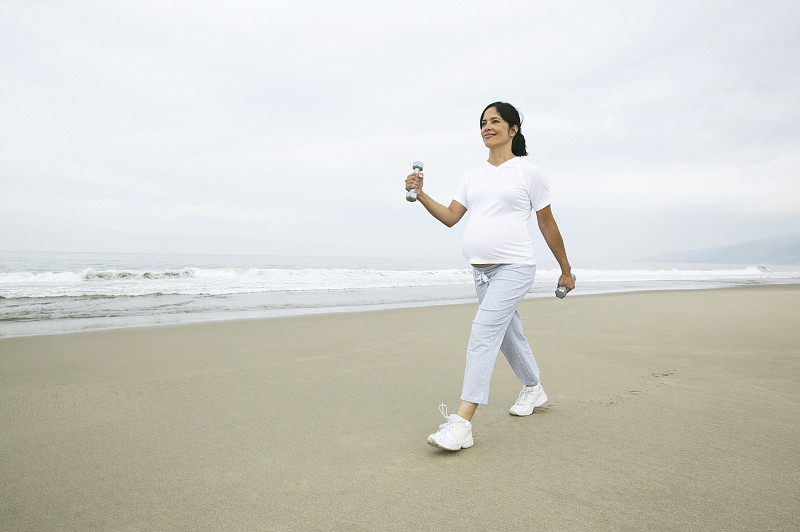 孕妇在海滩上锻炼步行图片下载