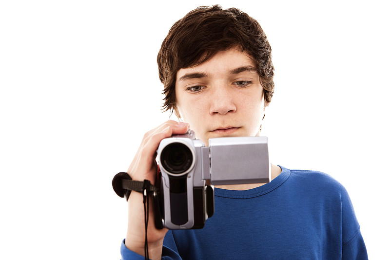十几岁的男孩拿着摄像机，近距离工作室肖像图片下载