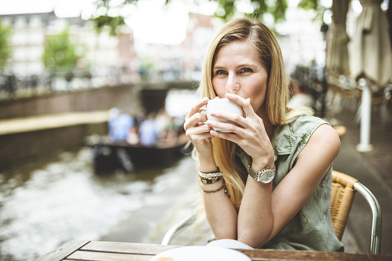 阿姆斯特丹一个拿着咖啡杯的女人图片下载