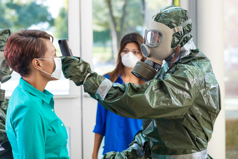 在传染病爆发期间，身着防护服的医生正在检查一位妇女图片下载