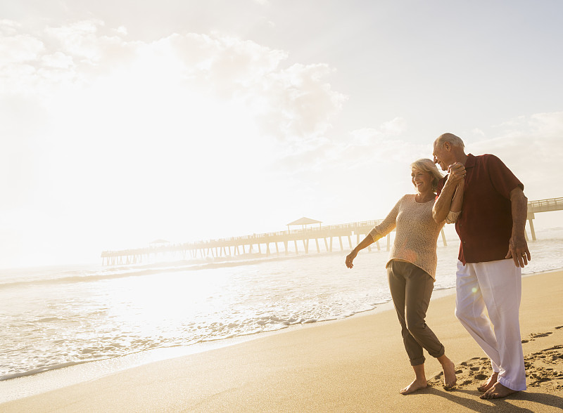 美国，佛罗里达，朱庇特，一对老年夫妇在海滩上散步图片下载