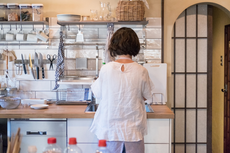 日本妇女在现代家庭厨房，烹饪和洗盘子图片下载