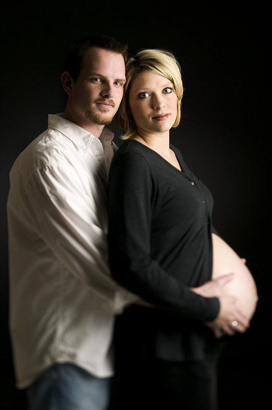 一个成熟男人拥抱孕妇的侧面图图片下载