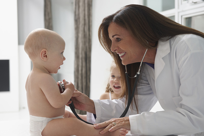 一个白人医生在听婴儿的心跳图片下载