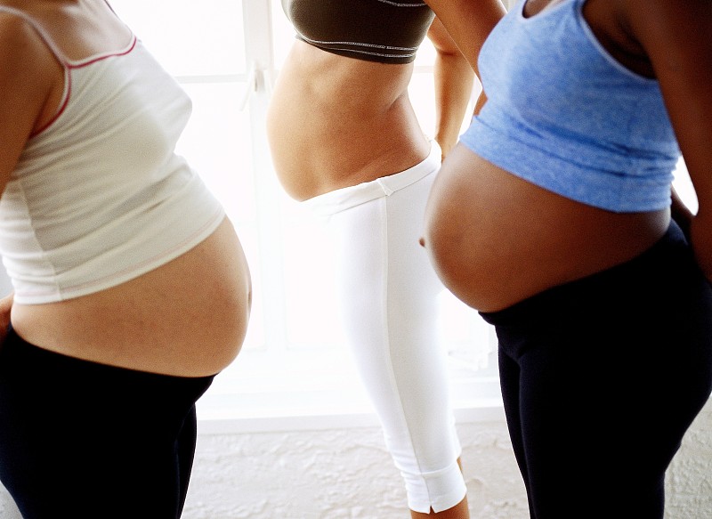 侧面特写的三个孕妇的肚子图片下载