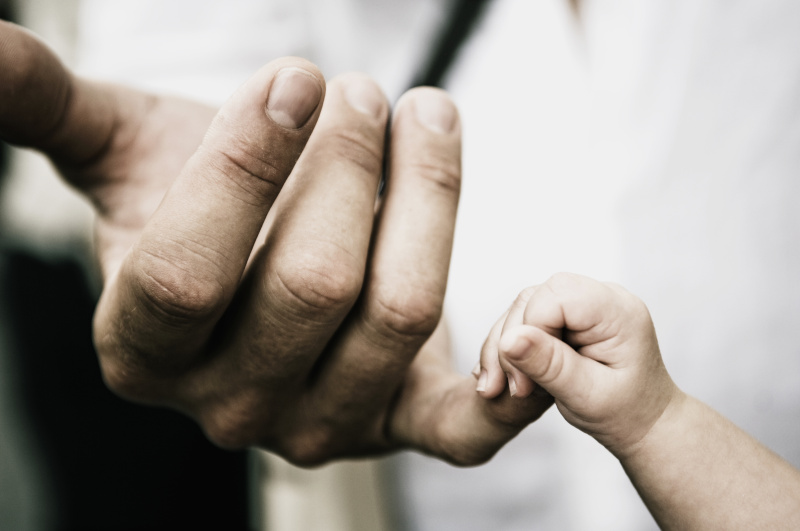 婴儿握着父亲的手指图片素材