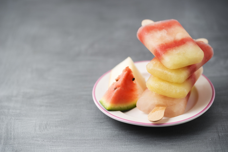 盘子里有不同种类的自制甜瓜冰棒图片素材