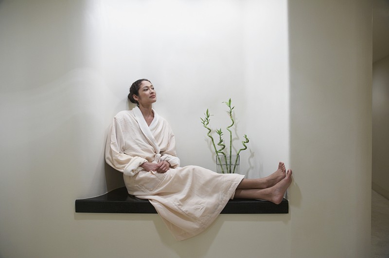 穿着浴袍的女人坐在水疗室里图片下载