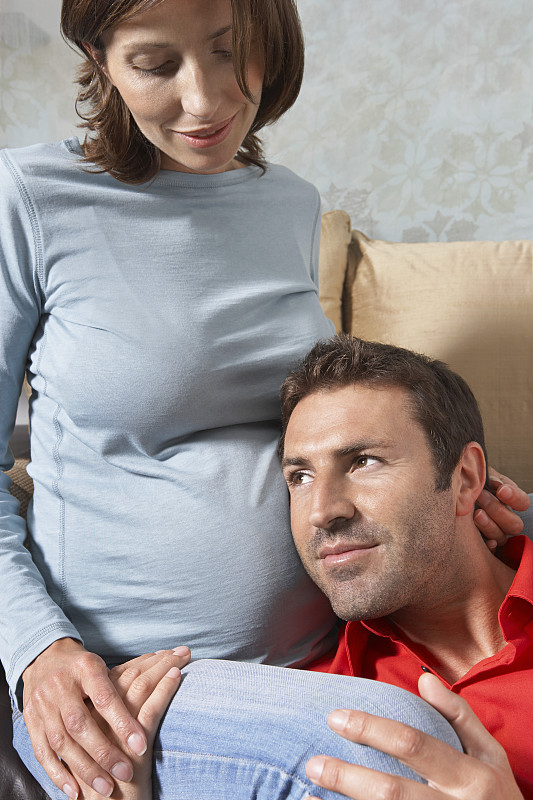 男人倾听孕妇的胃图片下载