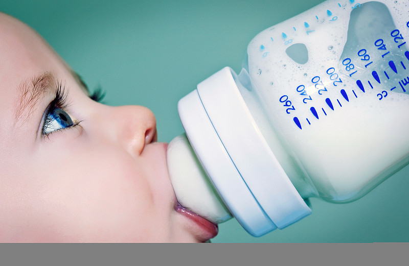 婴儿用奶瓶喝牛奶(或配方奶粉)图片下载