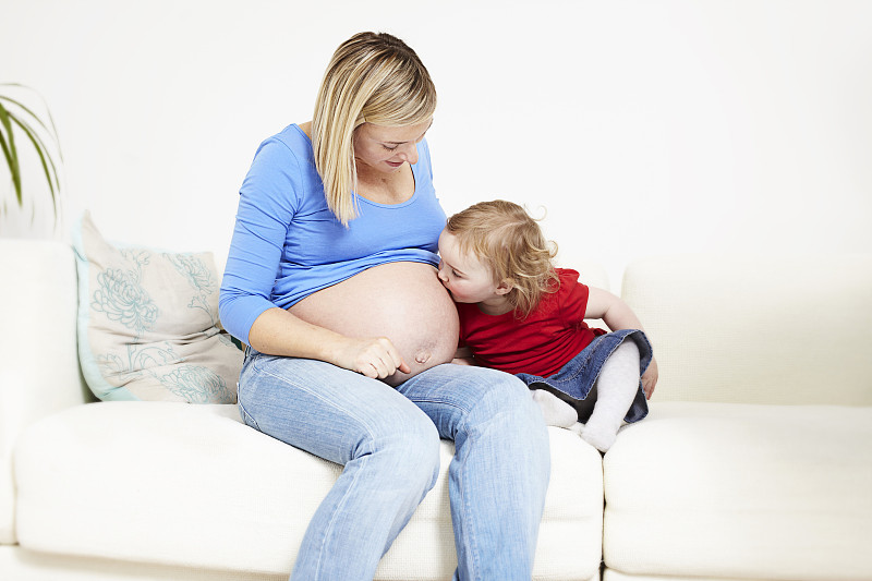 婴儿亲吻孕妇的肚子图片下载