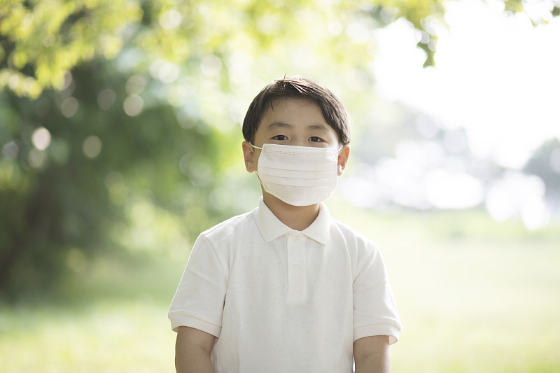 一个男孩在户外戴着流感口罩图片素材