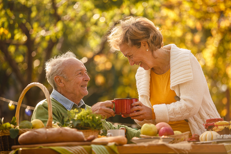 快乐的老年夫妇一边喝茶一边欢呼图片素材